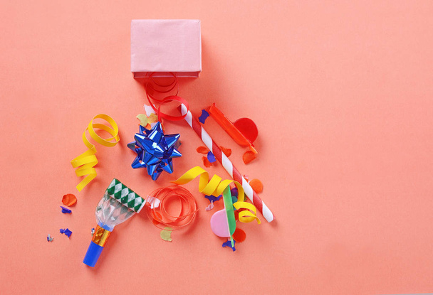 Red gift box with party confetti, streamers and noisemakers  - Photo, Image