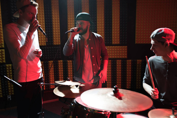 Muotokuva modernin hip-hop bändi esiintymässä äänitysstudio palaa punaisia valoja tehdessään uutta albumia
 - Valokuva, kuva