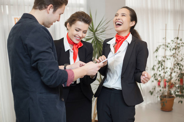 Portrait of three carefree office workers laughing while chatting in modern office - Photo, Image