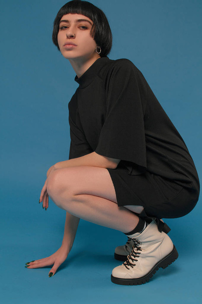 Fille avec de belles jambes dans des chaussures de mode sur un fond bleu
 - Photo, image