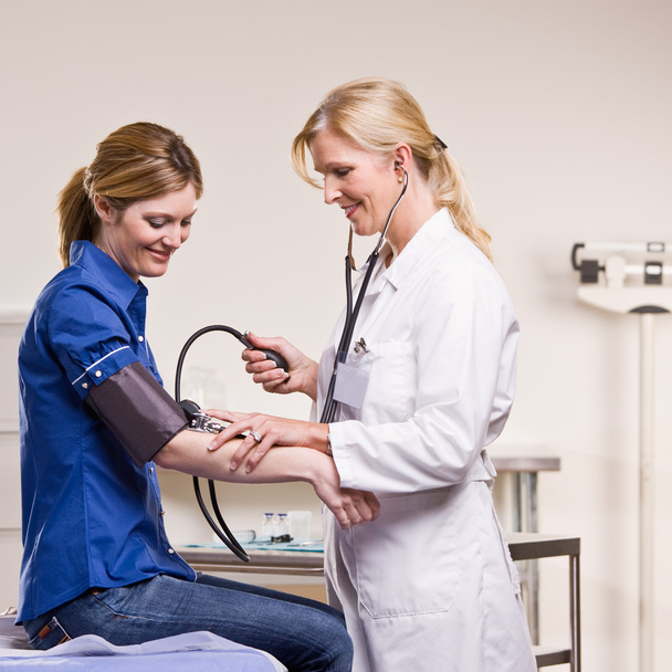 Doctor checking woman blood pressure - Φωτογραφία, εικόνα