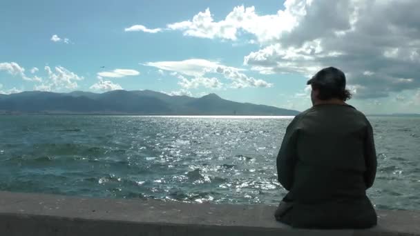 1920x1080 25 Fps. Muy agradable anciano solo hombre sentado a la orilla del mar mirando Seascape vídeo
. - Metraje, vídeo