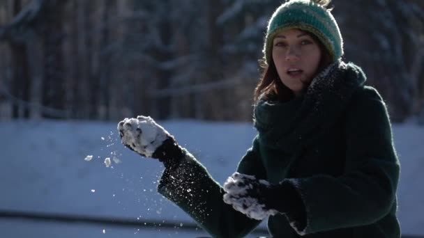 Slow-mo záběry. Krásná mladá dívka házet sněhové koule na kameru - Záběry, video