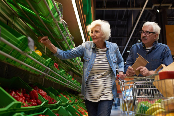 Portrét moderní starší pár s nákupní košík výběru ovoce a zeleniny v supermarketu při nakupování, kopie prostor - Fotografie, Obrázek