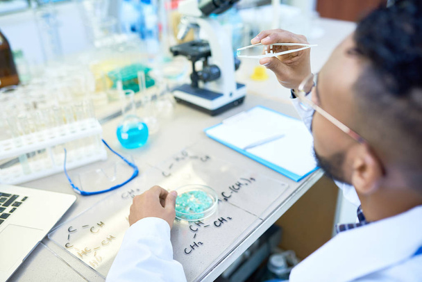 Μεγάλη γωνία πορτρέτο του νέους Μέσης Ανατολής επιστήμονας που εργάζεται με τρυβλίο Petri, σπουδάζουν βακτήρια στο σύγχρονο ιατρικό εργαστήριο, αντίγραφο χώρου - Φωτογραφία, εικόνα