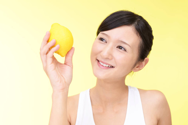 Mulher sorrindo com um limão
 - Foto, Imagem