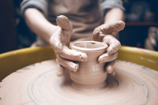 ceramic workshop - the girl makes a pot of clay  - Foto, afbeelding
