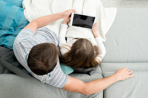 Sopra la vista del padre che utilizza tablet digitale godersi la serata con figlia adolescente e guardare film, copiare spazio
 - Foto, immagini