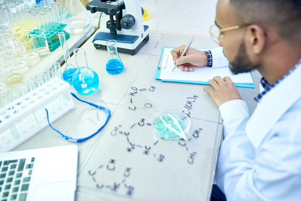 Высокоугловой портрет молодого ближневосточного ученого, изучающего химические структуры в современной медицинской лаборатории, копировальное пространство
 - Фото, изображение