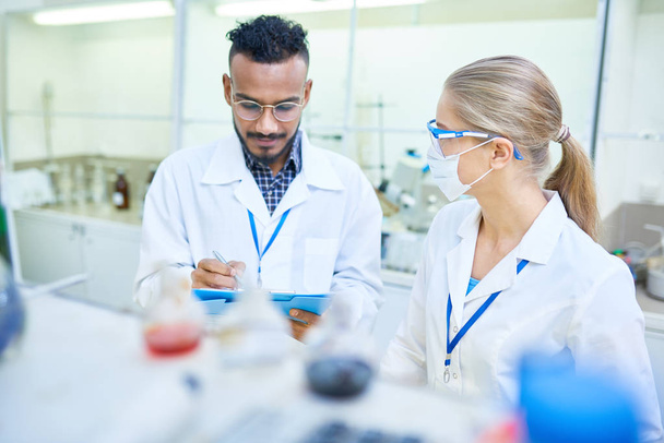 Retrato de uma equipe internacional de cientistas trabalhando juntos em laboratório médico fazendo pesquisa sobre produtos químicos e bactérias
 - Foto, Imagem
