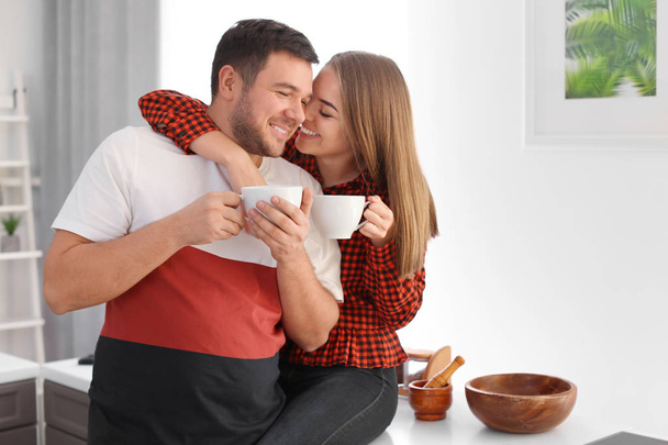 Cute young lovely couple drinking tea at home - Фото, изображение