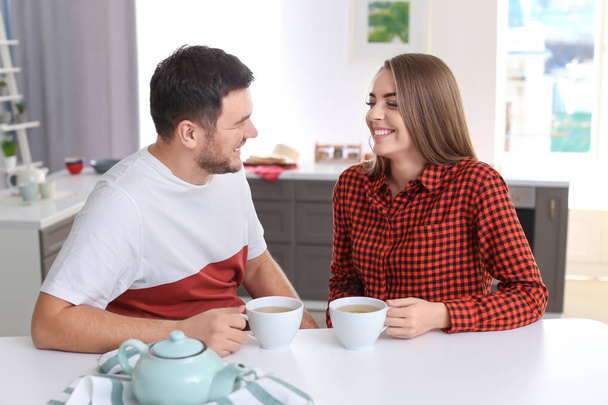 Cute young lovely couple drinking tea in kitchen - Фото, зображення