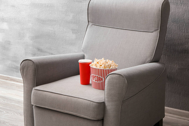 Comfortable armchair with popcorn and drink indoors. Home cinema - Fotó, kép