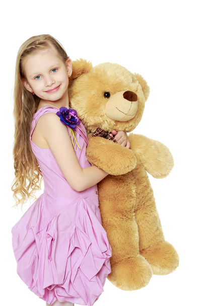 Beautiful little girl 5-6 years.She is holding a large teddy bea - Foto, Imagem