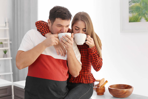 Cute young lovely couple drinking tea at home - Foto, Imagen