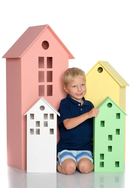 A little boy is playing with colorful houses. - 写真・画像