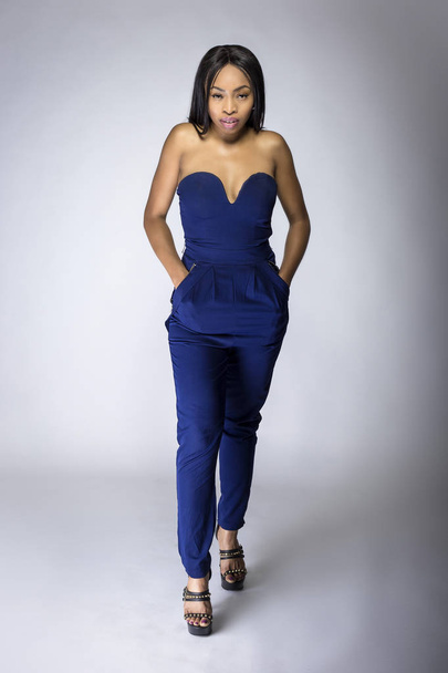 Sexy black female fashion model wearing apparel with blue pants.  The outfit is modern style for spring or summer clothing collection. The image depicts trends in womenswear - Foto, imagen