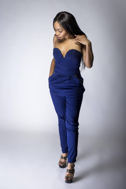 Sexy black female fashion model wearing apparel with blue pants.  The outfit is modern style for spring or summer clothing collection. The image depicts trends in womenswear - Photo, Image