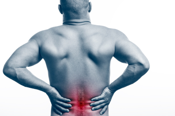 Lesión de columna vertebral. Joven hombre calvo físico deportivo sostiene una espalda enferma sobre un fondo blanco aislado. Fractura de columna vertebral
 - Foto, Imagen
