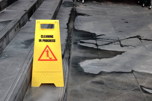 Panneau jaune de progrès de nettoyage de prudence sur le sol à l'extérieur
 - Photo, image