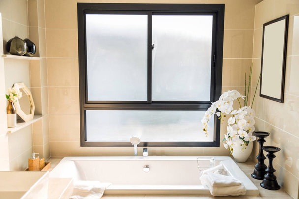 Un lujoso baño biege con bañera blanca e ingenio de toalla blanca
 - Foto, Imagen