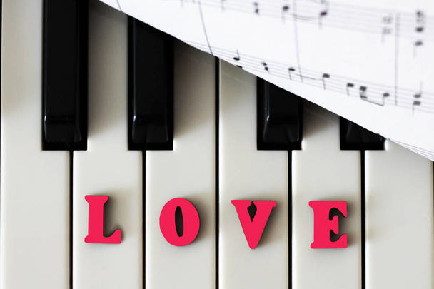 Klaviertasten in Nahaufnahme mit den Buchstaben Liebe und Herz. das ursprüngliche Kunstbild mit Valentin. - Foto, Bild