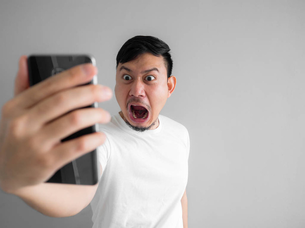 Shocked and scary face of man get yelled from smartphone.  See s - Фото, изображение