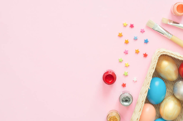 flache Lay Draufsicht bunte Osterei in Pastellfarben Komposition mit Pinsel auf rosa Pastellfarbe Hintergrund gemalt. Ostertag Hintergrund von oben mit Kopierraum. - Foto, Bild