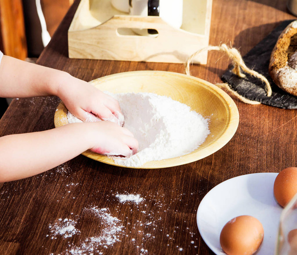 children's hands in a bowl of flour - Foto, afbeelding
