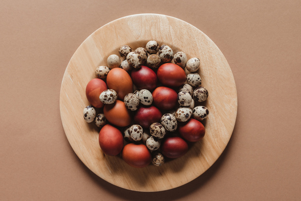 top view of chicken and quail easter eggs on wooden plate - Φωτογραφία, εικόνα