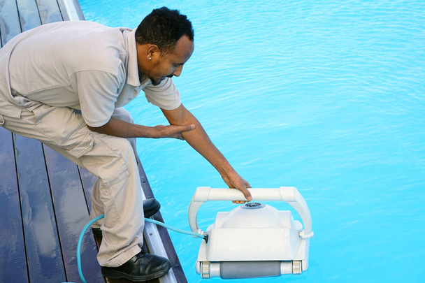 Hotel staff worker cleaning the pool - Photo, Image
