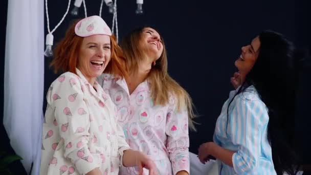 Womens pyjama partij, drie mooie en sexy meisjes lachen en dansen op het bed. - Video