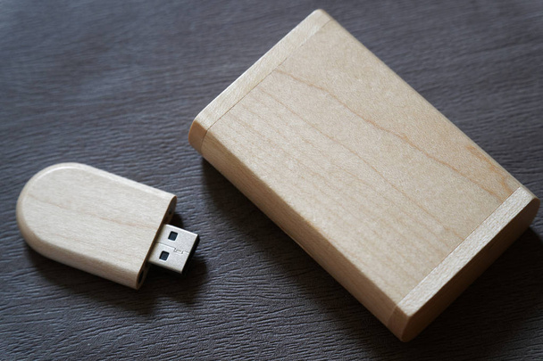 Lecteur flash USB avec surface en bois dans une boîte en bois sur le bureau pour port USB ordinateur portable pour le transfert de données et le concept d'entreprise de sauvegarde
 - Photo, image