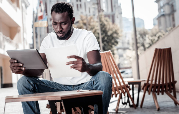 Serious male entrepreneur thinking over business documents outdoors - 写真・画像