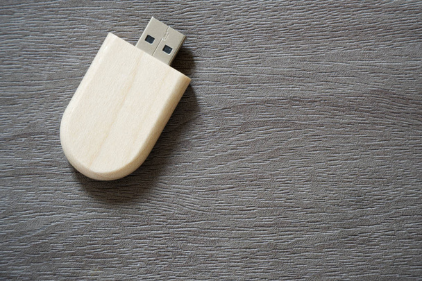 Lecteur flash USB avec surface en bois sur le bureau pour port USB plug-in ordinateur portable pour le transfert de données et concept d'entreprise de sauvegarde
 - Photo, image