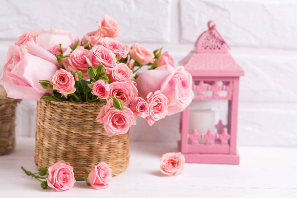 Pink roses flowers and decorative pink  lantern against  white brick wall. Floral still life.  Selective focus. Place for text. - Φωτογραφία, εικόνα