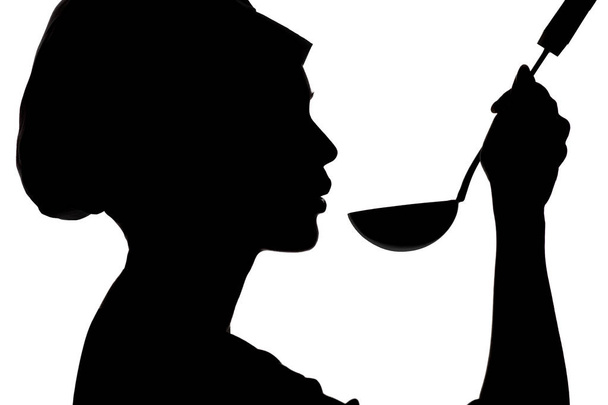 silhouette of woman cooking in a cap, profile of a girl blowing at soup on ladle on a white isolated background - Photo, Image