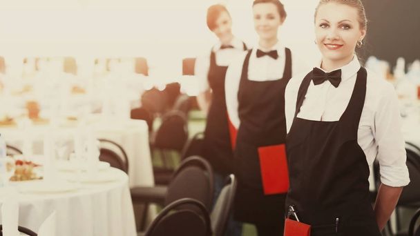 Un gran grupo de camareros y camareras junto a las mesas servidas
 - Foto, imagen