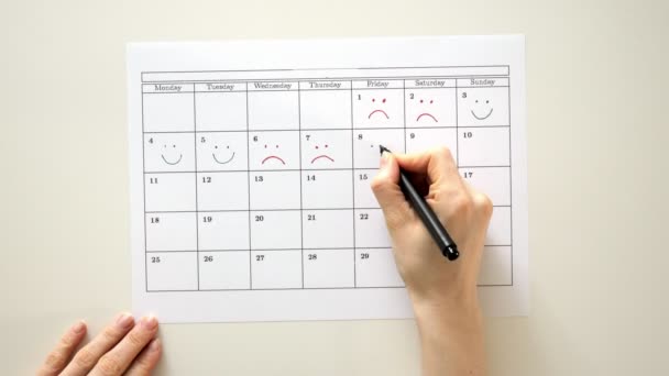 Sign the day in the calendar with a pen, draw a smile - Footage, Video