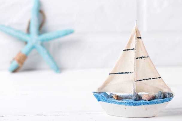 Coastal living  decorations.  Decorative boat and sea star  near by white brick wall. Selective focus. Place for text. - Foto, Imagen