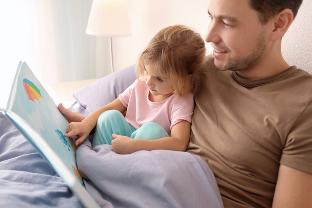 Father with little daughter reading bedtime story at home - Φωτογραφία, εικόνα