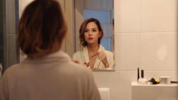 Fiatal gyönyörű nő sminkelünk a fürdőszobában  - Felvétel, videó