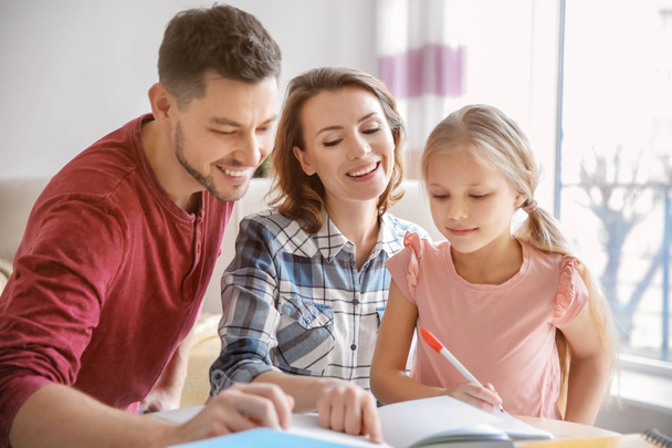 Little girl with parents doing homework at home - Foto, Imagen