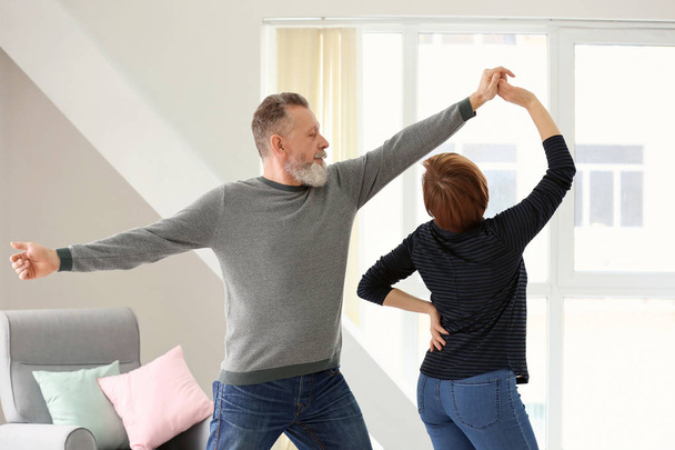 Happy mature couple dancing at home - 写真・画像