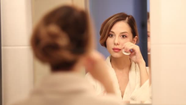 Mladá krásná žena čištění obličeje v koupelně  - Záběry, video