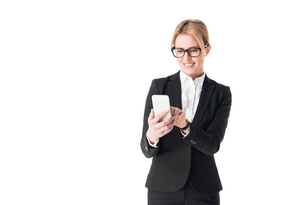 Smiling businesswoman using smartphone isolated on white - Фото, изображение