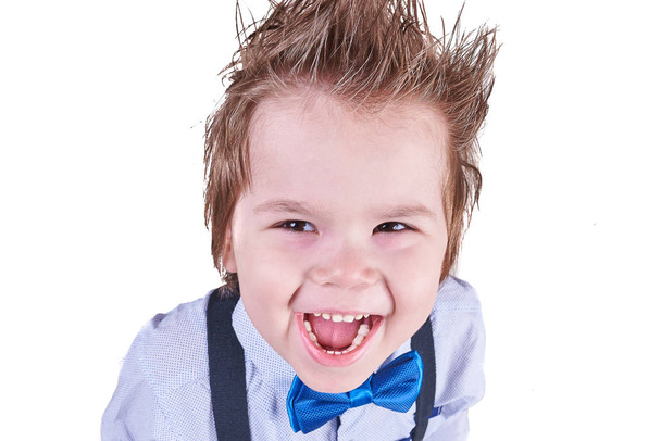 Petit garçon souriant dans un nœud papillon bleu et bretelles, isolé sur fond blanc
 - Photo, image