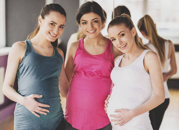 Happy pregnant women are looking at the camera - Foto, imagen