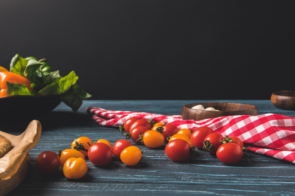 cherry tomatoes and tablecloth on wooden table - Fotoğraf, Görsel