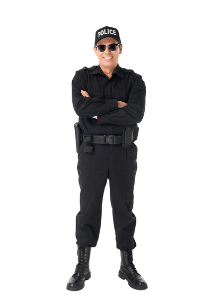 Smiling policeman with arms folded isolated on white - Foto, imagen